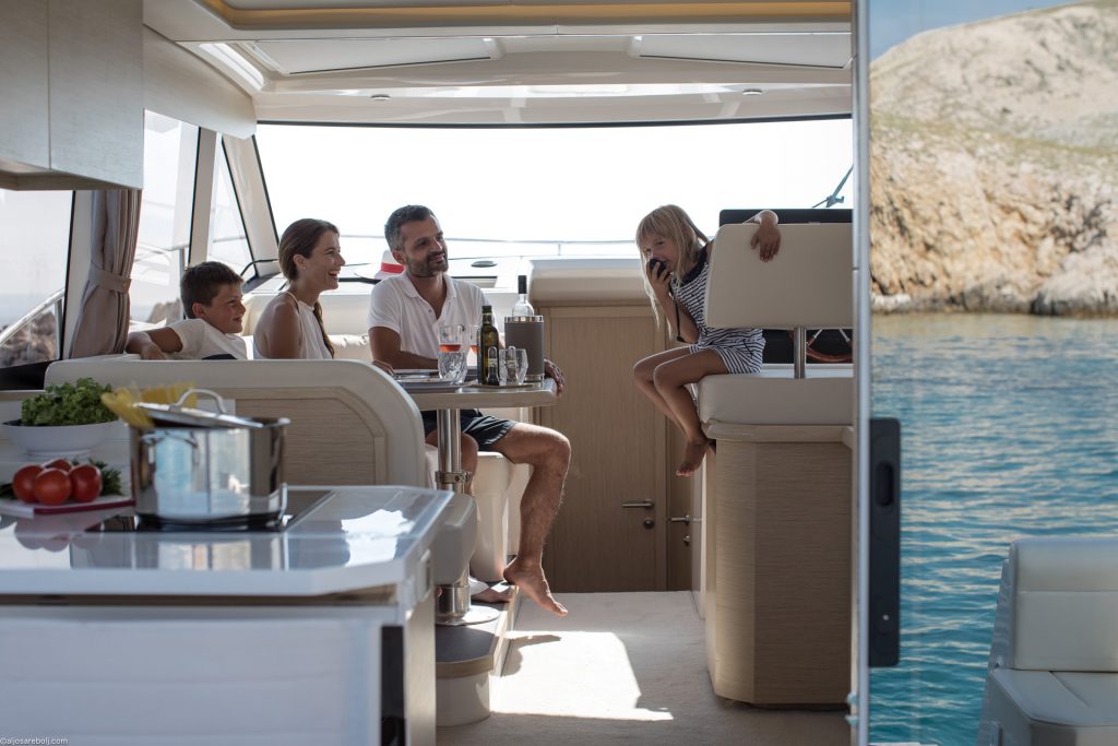 Family gathered in the Greenline 39 saloon with the galley open to the cockpit
