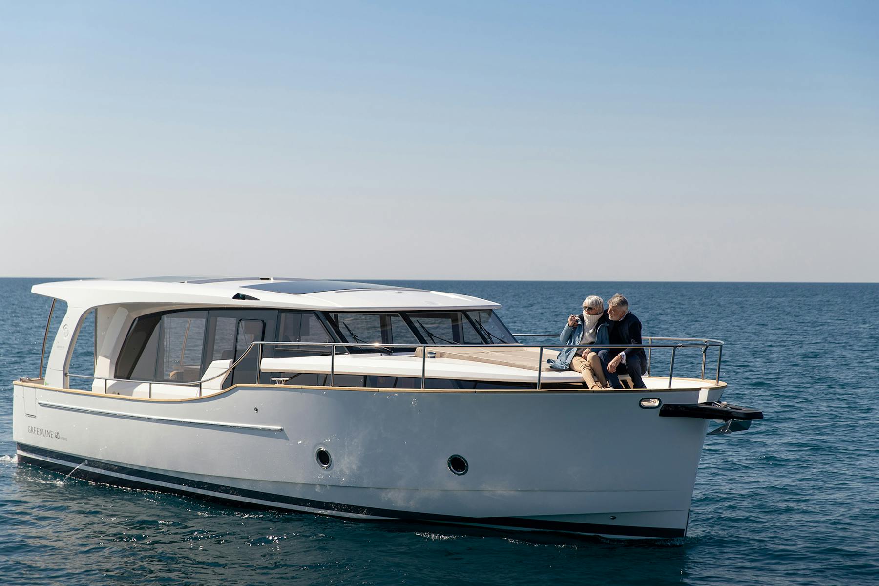 Couple relaxing on the bow of a Greenline 40