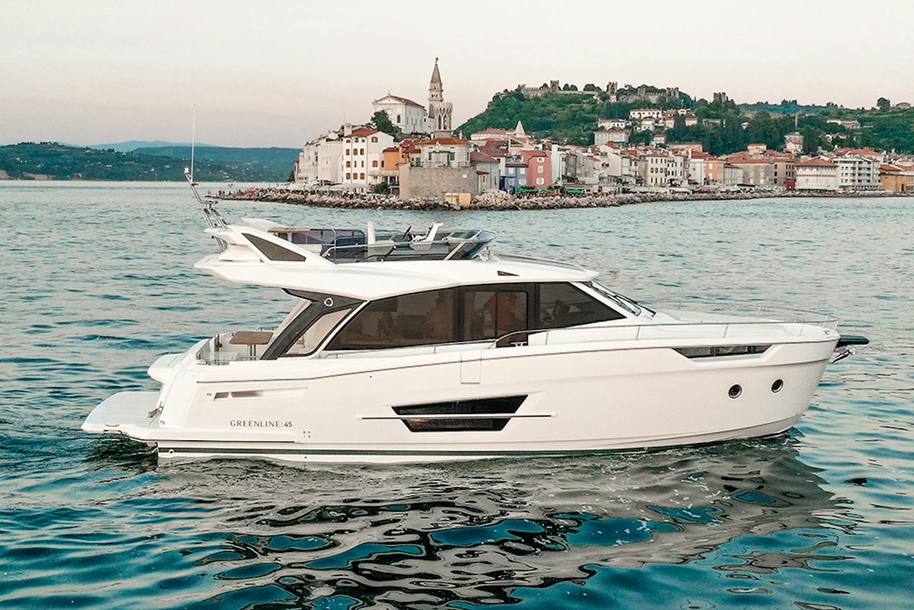 Greenline 45 Fly cruising past a coastal town