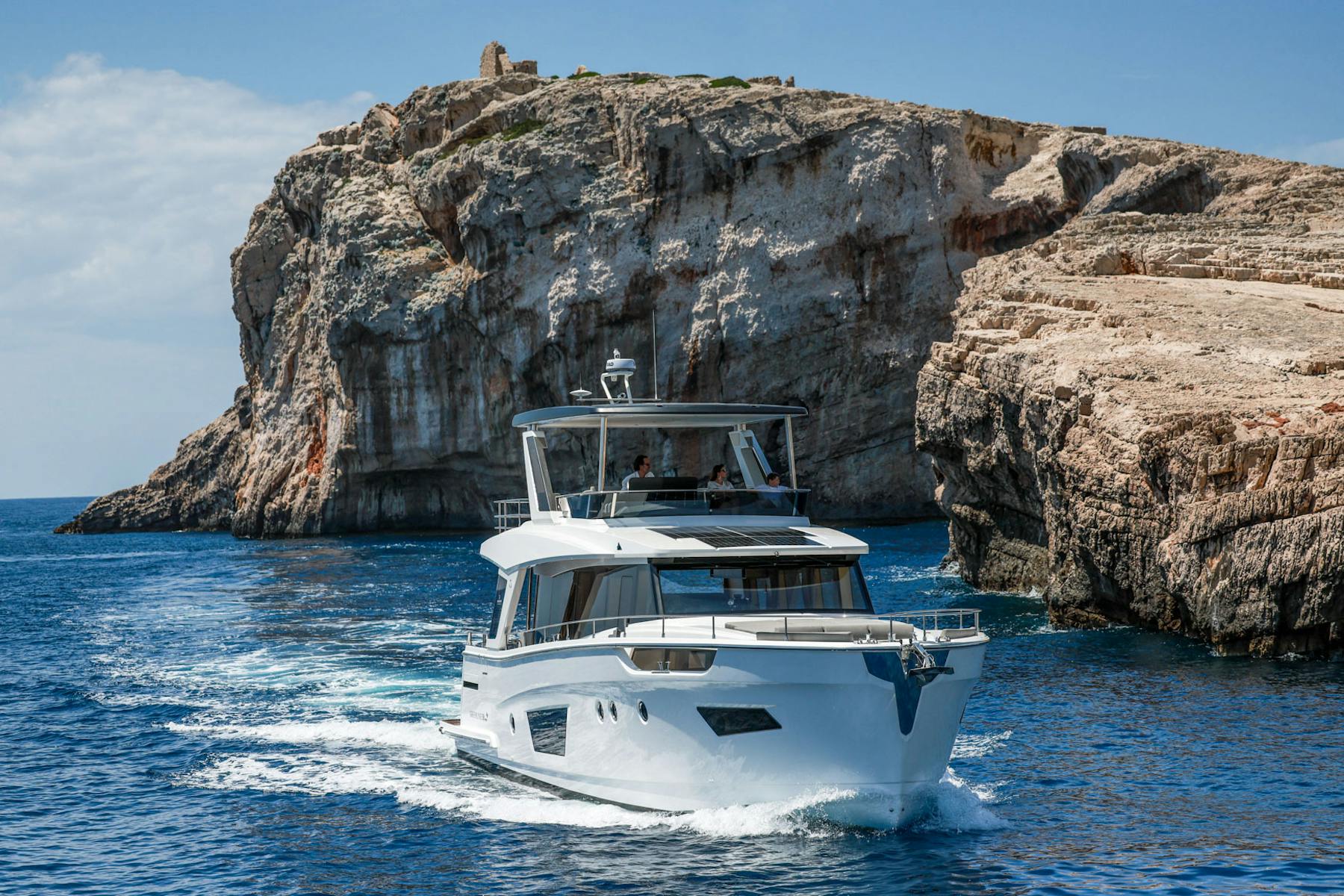 Greenline 58 Fly cruising beside rocky coastal cliffs